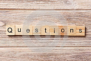 Questions word written on wood block. Questions text on table, concept