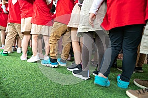 Queue of Asian kids in school uniform standing in line