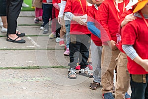 Queue of Asian kids in school uniform standing in line