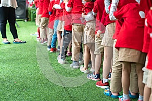 Queue of Asian kids in school uniform standing in line