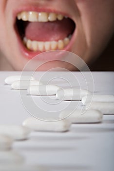 Queue of chewing gums heading to open mouth