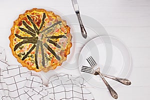 Quiche with green asparagus and salmon on white