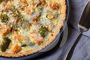Quiche open pie with trout, broccoli and cheese. Homemade unsweetened pastries, traditional pie.