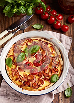 Quiche open tart pie with ham and tomatoes filled with cream, cheese and eggs