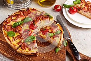 Quiche open tart pie with ham and tomatoes filled with cream, cheese and eggs