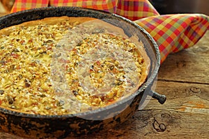 Quiche pie with chicken, green pepper, ham and mushroom in blac