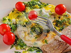 Quick Breakfast Omelet with greens, cherry tomatoes, bread grains