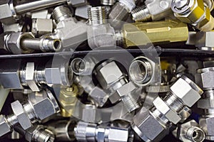 Quick connect fitting coupling for compressed air, hydraulics, pneumatics, gases, fuels lie in a chaotic manner in the box photo