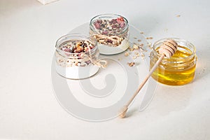 Quick healthy breakfast greek yogurt, honey, granola with dried berries and nuts in glass jar on stone table. Homemade granola par