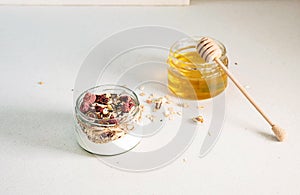 Quick healthy breakfast greek yogurt, honey, granola with dried berries and nuts in glass jar on stone table. Homemade granola par