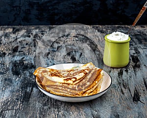 Quick homemade breakfast with pancakes and cream in a clay jar