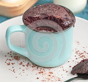 Chocolate biscuit cake in a blue ceramic mug, microwave baking. muffin