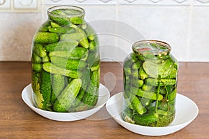 Quick pickled cucumbers in two different jars on kitchen table