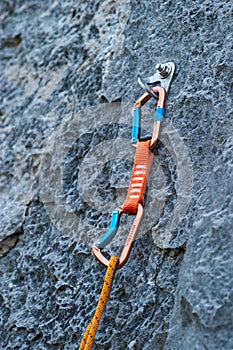 A quickdraw carabiner attached to a rock cliff