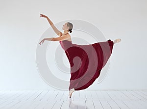 The quickest route to happiness is through dance. a young woman dancing in a ballet studio.