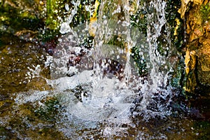 Quickly flowing mountain stream, close-up flowing water from the