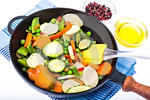 Quickly frozen vegetable mix in frying pan on white background