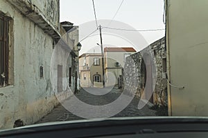 Quiet afternoon in traditional small street in greek village in Crete, Greece. Typical narrow alley in cute ancient town