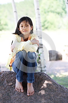 Quiet child sitting under trees