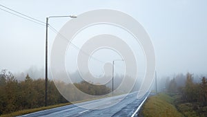 Quiet foggy road. Empty two lane road in a forest.