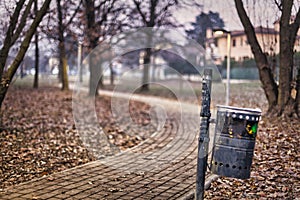 Quiet path in the town park trash bin