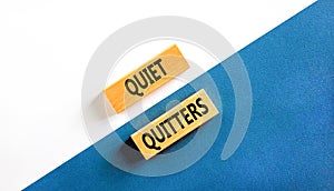 Quiet quitters symbol. Concept words Quiet quitters on wooden blocks. Beautiful white and blue background. White and blue paper.