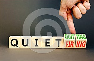 Quiet quitting or firing symbol. Concept words Quiet quitting Quiet firing on cubes. Businessman hand. Beautiful grey table grey