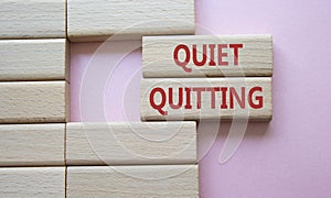 Quiet quitting symbol. Concept word Quiet quitting on wooden blocks. Beautiful pink background. Business and Quiet quitting