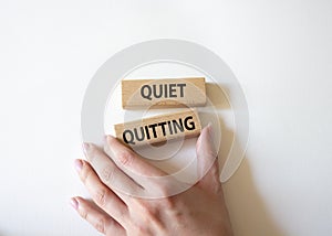 Quiet quitting symbol. Concept word Quiet quitting on wooden blocks. Beautiful white background. Businessman hand. Business and
