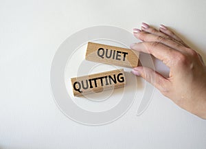 Quiet quitting symbol. Concept word Quiet quitting on wooden blocks. Beautiful white background. Businessman hand. Business and