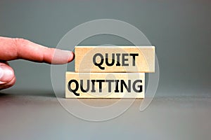 Quiet quitting symbol. Concept words Quiet quitting on wooden blocks. Beautiful grey table grey background. Businessman hand.