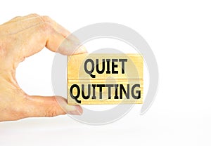 Quiet quitting symbol. Concept words Quiet quitting on wooden blocks. Beautiful white table white background. Businessman hand.