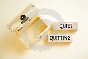 Quiet quitting symbol. Concept words Quiet quitting on wooden blocks. Beautiful white table white background. Empty wooden chest.