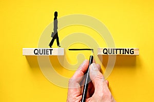 Quiet quitting symbol. Concept words Quiet quitting on wooden blocks. Beautiful yellow table yellow background. Businessman hand.