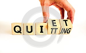Quiet quitting symbol. Concept words Quiet quitting on wooden cubes. Businessman hand. Beautiful white table white background.
