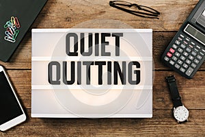 Quiet Quitting text headline in vintage style light box on office deskt op