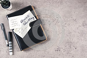 Quiet Quitting. Top view to desk with office supplies. Sticky note with written text Quiet Quitting on closed paper