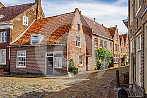 A quiet square with historic houses bordering the harbor of the fortified town of Heusden in North Brabant, Netherlands,