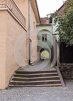 Quiet street, leaving the Fortress Square in the castle of old city. Sighisoara Ñity in Romania