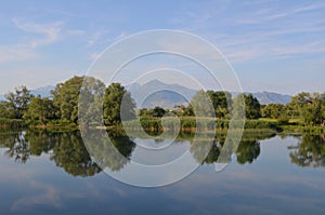 Quiet water of a lake allows beautiful mirror reflections on sunny day. Amazing wilderness nature landscape panorama.