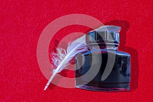 Quill Pen and Ink Isolated on Bright Background. Close-up of a White Feather With an Inkwell