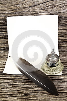 Quill pen and inkwell and old paper