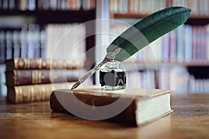 Quill pen on an old book in a library