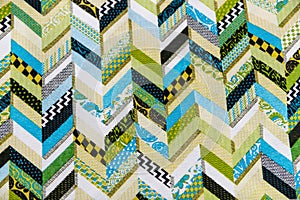 A quilt with a green and white pattern of chevrons