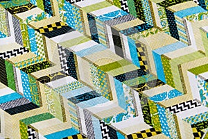 A quilt with a green and white pattern of chevrons