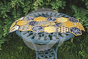 Quilt Honeycomb front on a garden green steel table