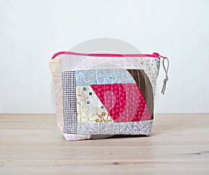 Quilted patchwork makeup bag on wooden deskQuilted patchwork notions bag on wooden desk