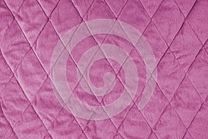 Quilted pink velours fabric background, wrinkled soft blanket surface