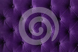 Quilted velour buttoned purple violet color fabric wall pattern background. Elegant vintage luxury sofa upholstery. Interior plush photo