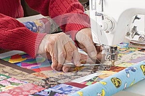 Quilter cutting thread on sewing machine.